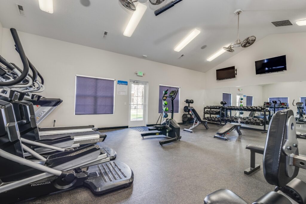 fitness center with cardio equipment and weights