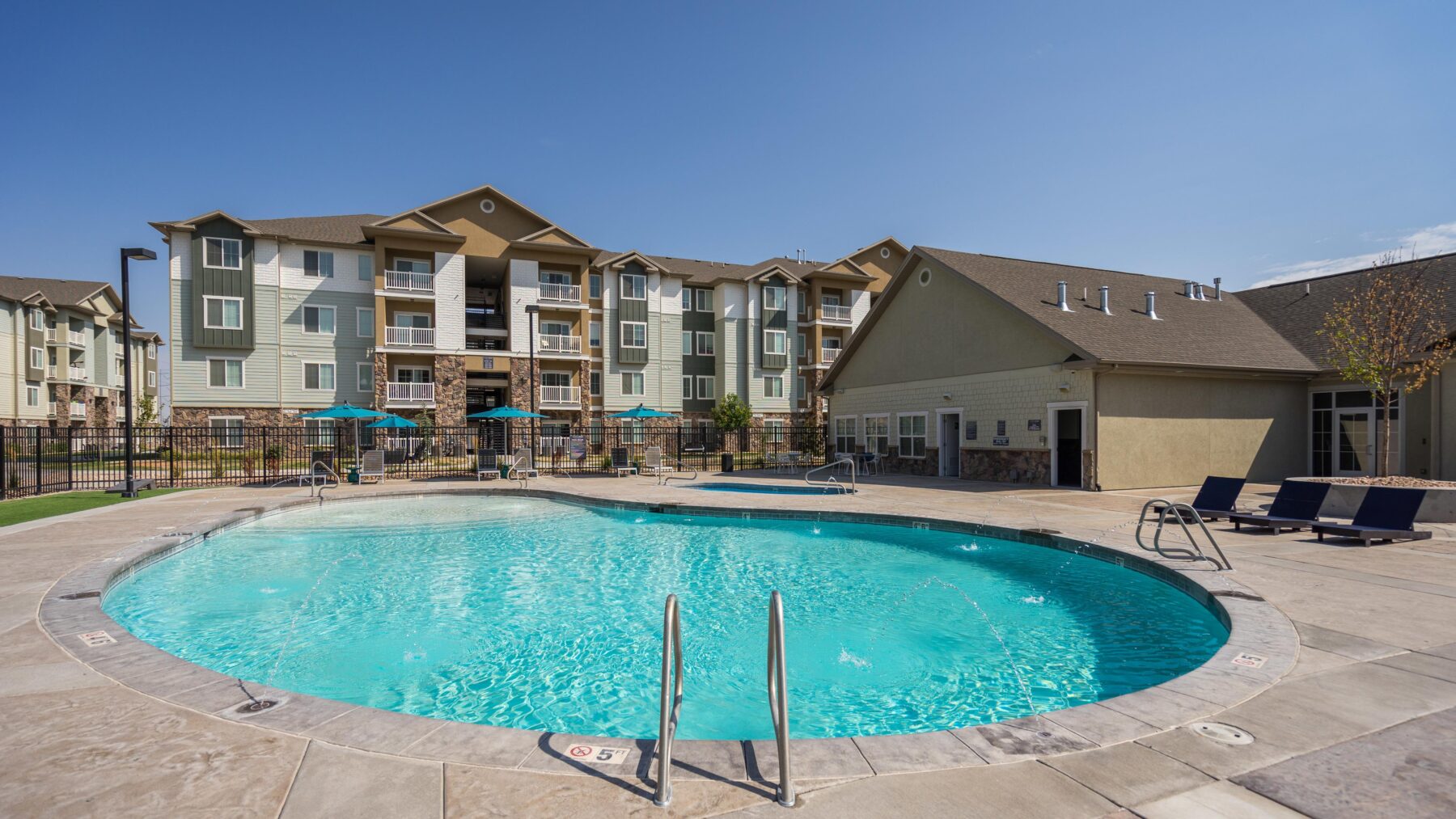 Swimming pool with deck seating and umbrellas