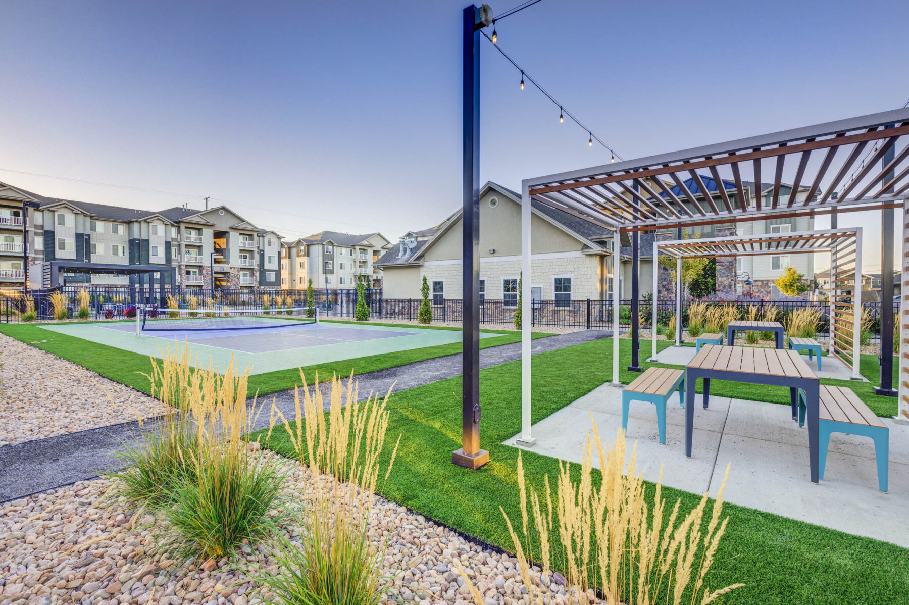 Pickle ball Court with seating area surrounded by the apartments