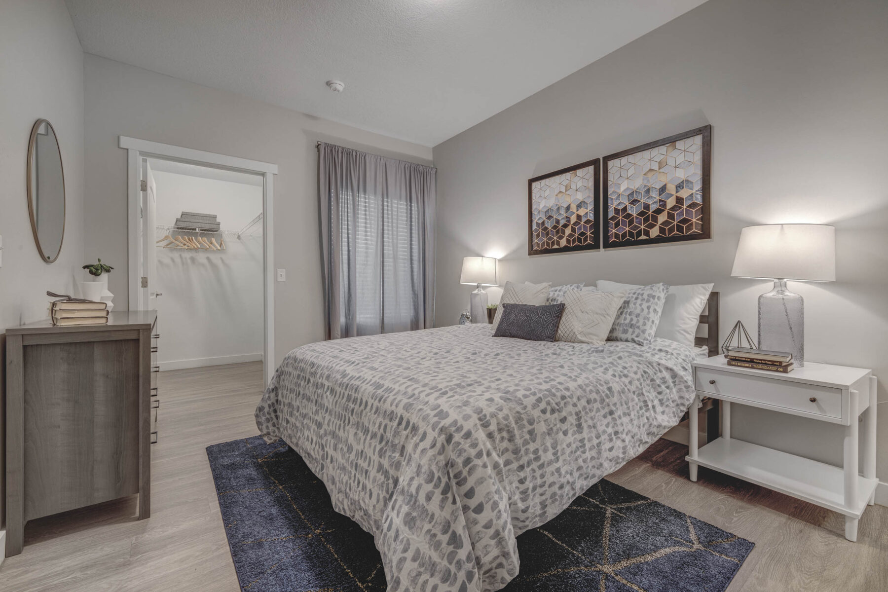 Bedroom with a bedside tables on either side of the bed, wall art and a walk in closet