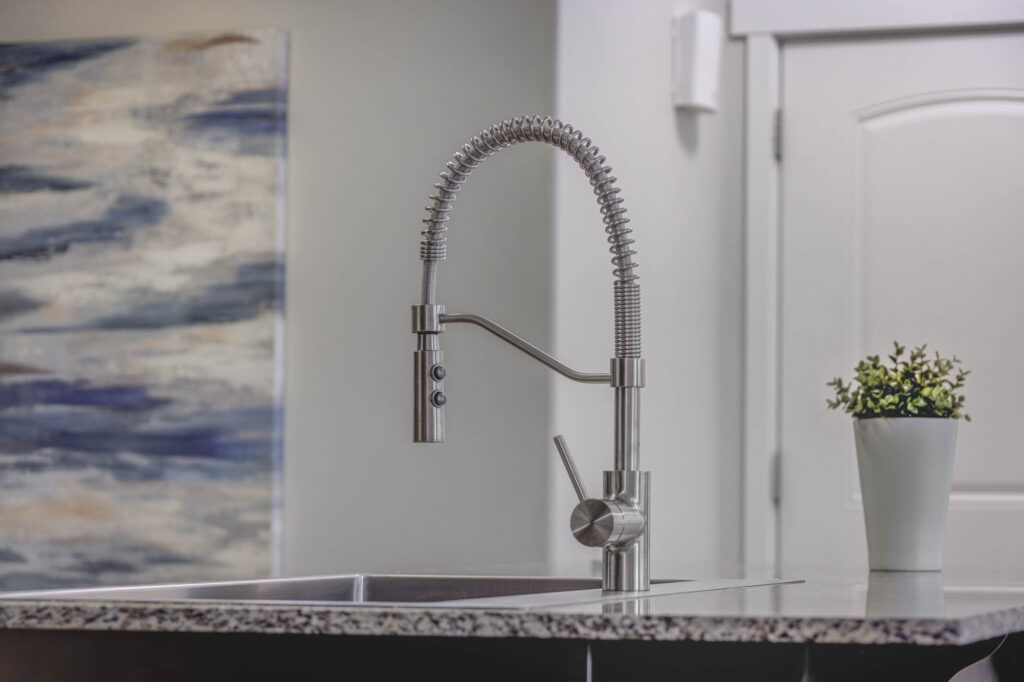 Kitchen with dark wooden cabinets, modern appliances and a kitchen island with stools
